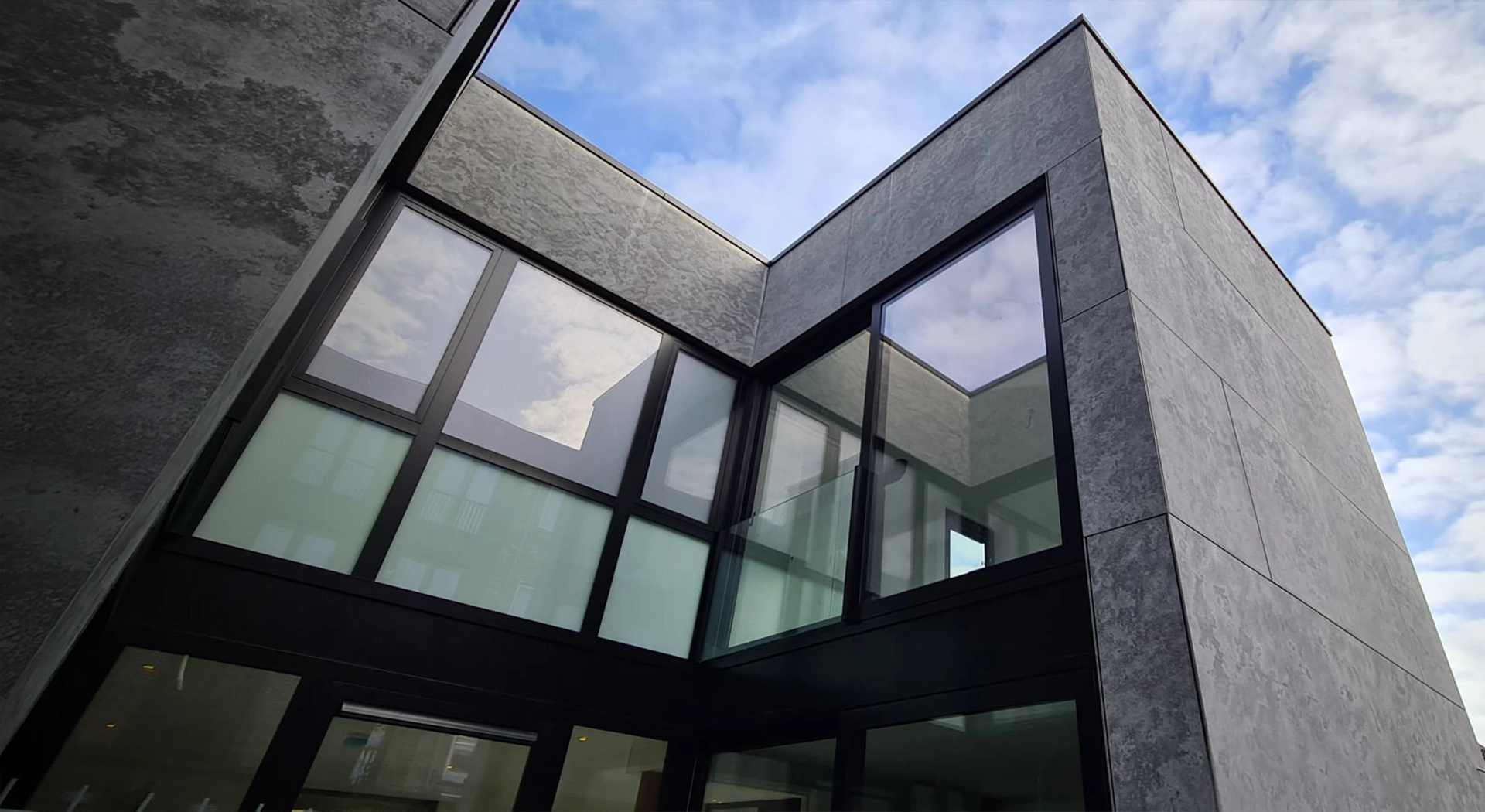 Modern woongebouw in Amsterdam met zwarte aluminium kozijnen en grote glaspartijen, geproduceerd door ons met Reynaers aluminium systemen