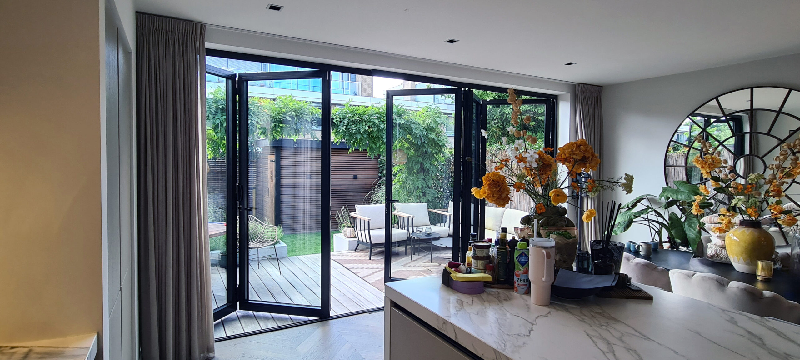 Renovatieproject in Amsterdam met aluminium harmonicadeur naar tuin, volledig open te vouwen voor maximale binnen-buiten verbinding